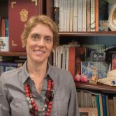 Alexandra Anyfanti standing in front of bookshelf