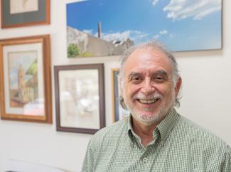 Alex Coles smiling in his office