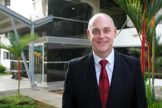 Carlos Guevara Mann standing in front of the FSU Panama main building