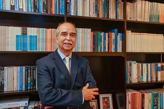 Carlos Ricardo Langoni in front of book shelf